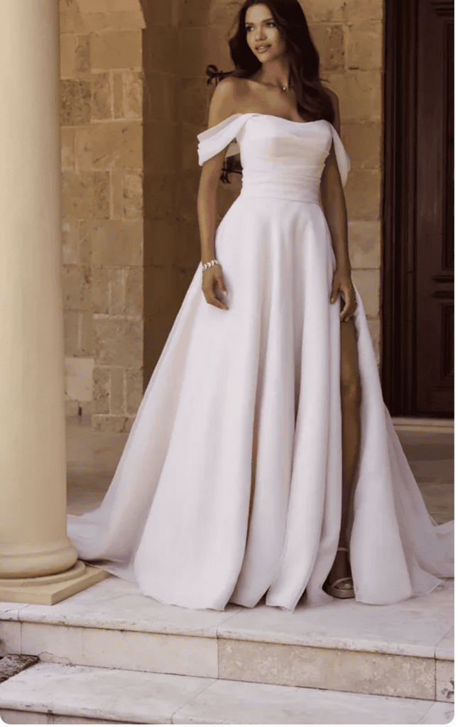 off-the-shoulder blush bridal gown with a ruched bodice and a leg slit
