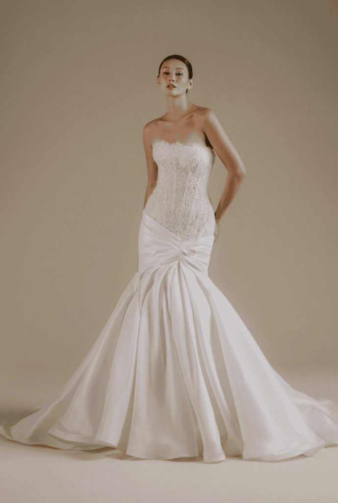 wedding gown featuring a sculptured lace bodice and sating draping 
