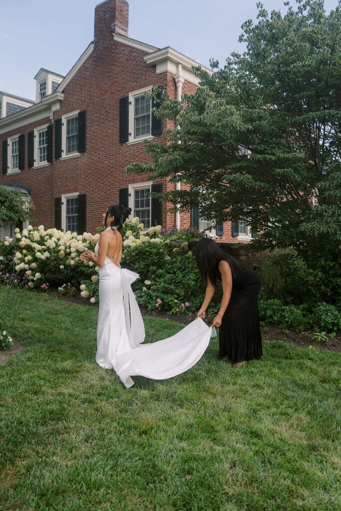 Wedding planner fixing train on wedding dress